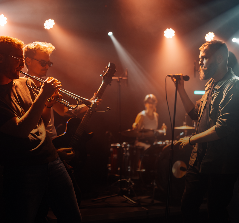 Musicians playing instruments under stage lights