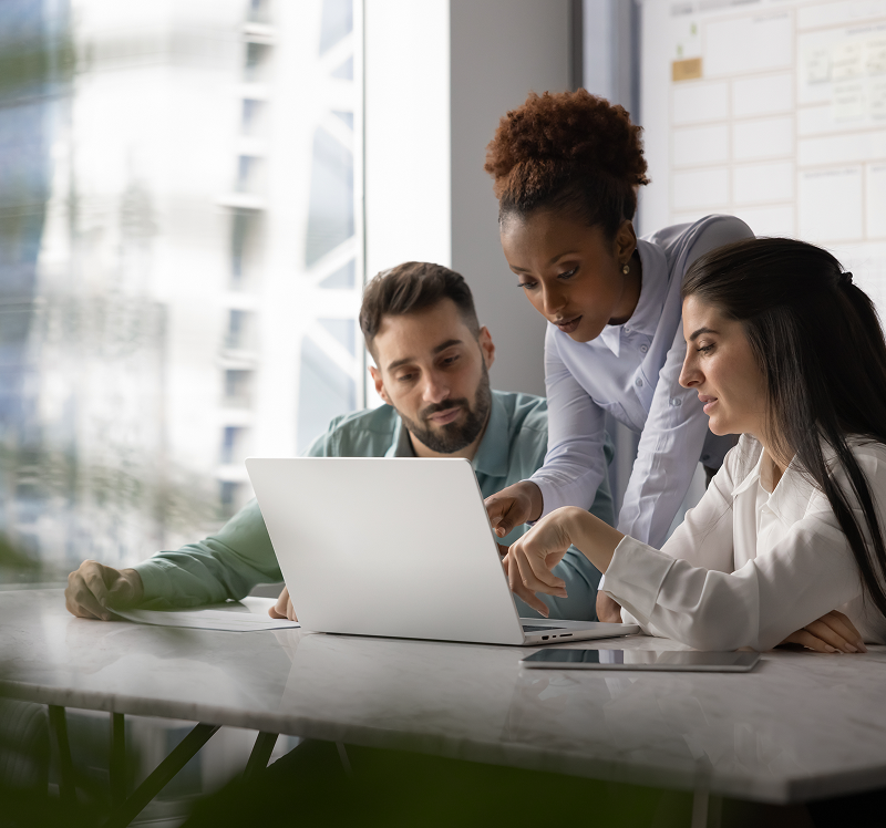 Team collaborating on laptop in office
