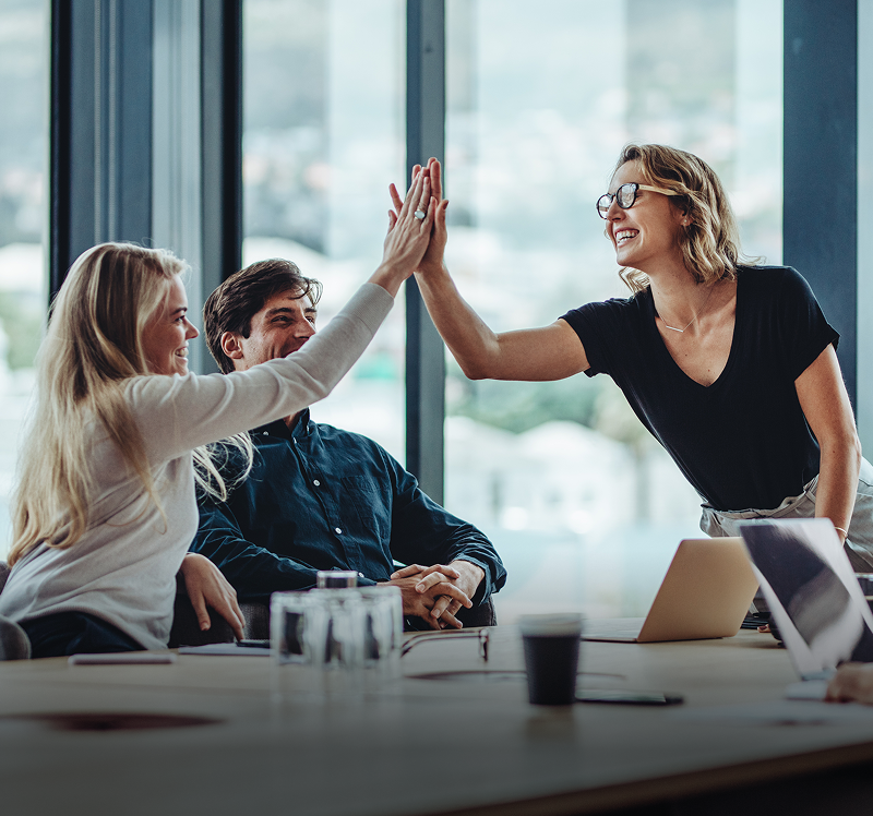 Colleagues high-fiving at table